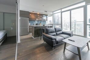 A modern apartment with a kitchen, a sofa, and a dining table. - Luxury Downtown 1BD Suite w/ Rooftop Terrace | Minutes to ByWard Market (Ottawa)