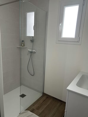 Een douche, een haardroger, zeep, toiletpapier