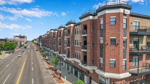 Una hilera de casas adosadas de ladrillo con balcones, una calle despejada y una acera para peatones.