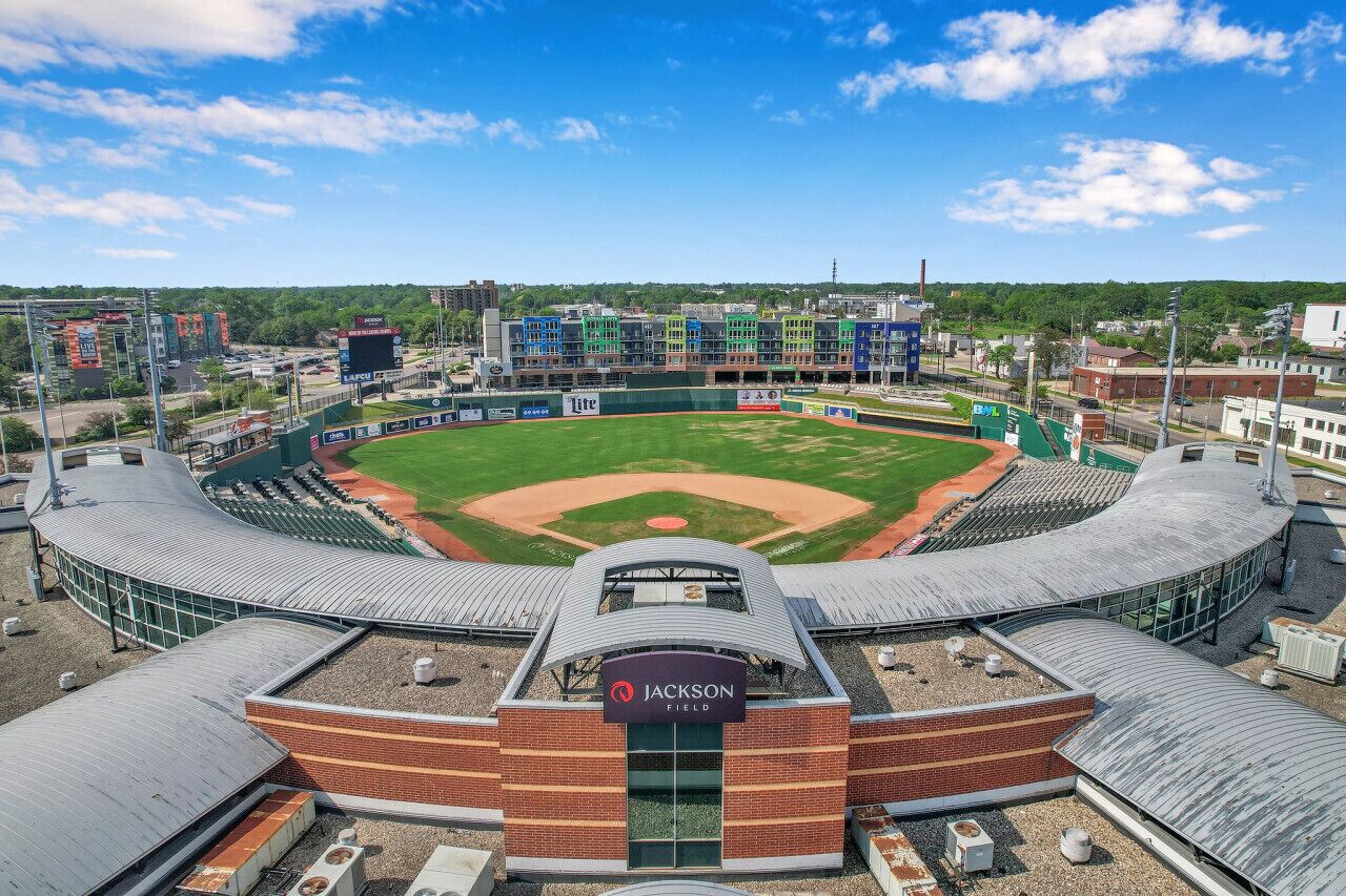 Un stade de baseball doté d’un toit incurvé, d’un terrain central et d’un tableau d’affichage.