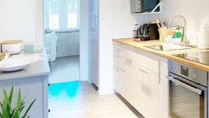 Una cocina moderna con armarios blancos, electrodomésticos de acero inoxidable y encimera de madera.