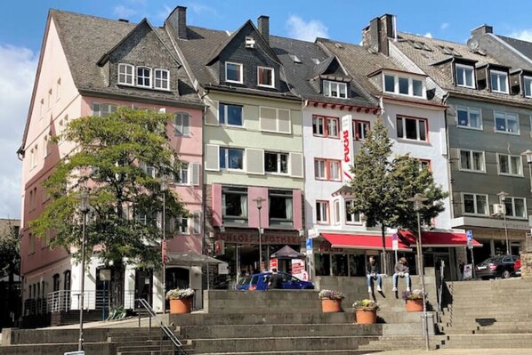 A row of colorful buildings with a central staircase leading to a covered area.