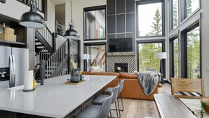 Una cocina moderna con una isla central, taburetes de bar y una chimenea.