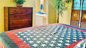 A bedroom with a bed covered in a star-patterned quilt, a wooden dresser, a ceiling fan, and two potted plants. - The perfect spot for family & friend! Best private getaway in Mohave Valley 🔆 (Mohave Valley)