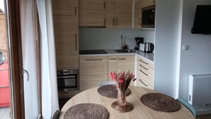 A modern kitchen with wooden cabinets, a microwave, and a sink. - 1st floor, view mountain, swimming pool, parking, tv, ski locker, 32m², La Joue du Loup (Agnières-en-Dévoluy)
