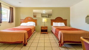 A hotel room with two beds, a nightstand with a lamp, a mirror, and a window with curtains. - The Inn by El Dorado Lake (El Dorado)