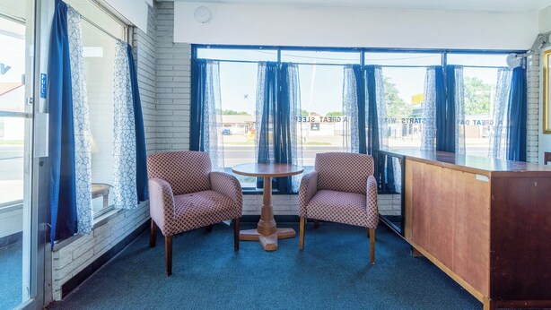 A room with two patterned chairs, a small round table, and a wooden desk. - The Inn by El Dorado Lake (El Dorado)