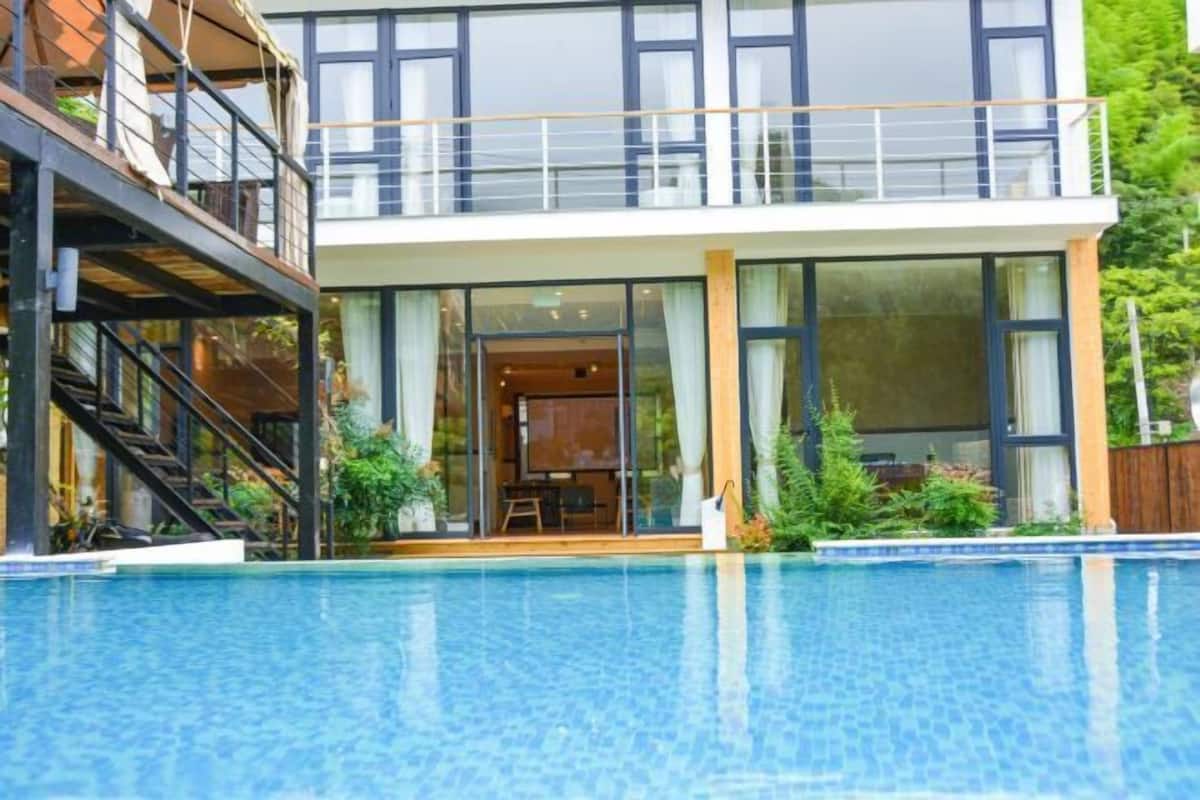 A modern two-story building with a swimming pool in front.