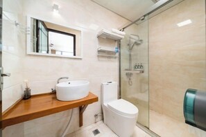 A modern bathroom with a wooden vanity, a white sink, a toilet, and a glass shower enclosure. - Yuanshan Hostel (Deqing)