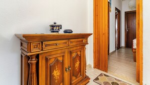 A wooden cabinet with drawers and a decorative top, a tiled floor, and a wooden door leading to another room. - Triple in B&B Stars - Close to the Sea and Absolute Relaxation (Sangineto)