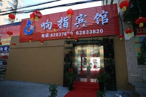 A hotel entrance with a red awning and a glass door. - Xiangzhi Hotel (Yueqing)