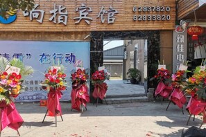A hotel entrance with a signboard, reception desk, and floral decorations. - Xiangzhi Hotel (Yueqing)