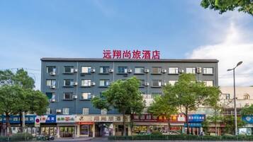 A hotel with multiple floors, a flat roof, and a sign indicating it is a hotel.