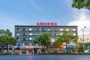 Un hotel con varios pisos, techo plano y un letrero que indica que es un hotel.