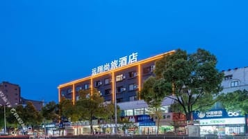 A hotel with a prominent sign, multiple floors, and a modern facade.