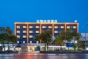 Un hôtel à plusieurs étages, reconnaissable à son grand panneau situé en haut de la façade.