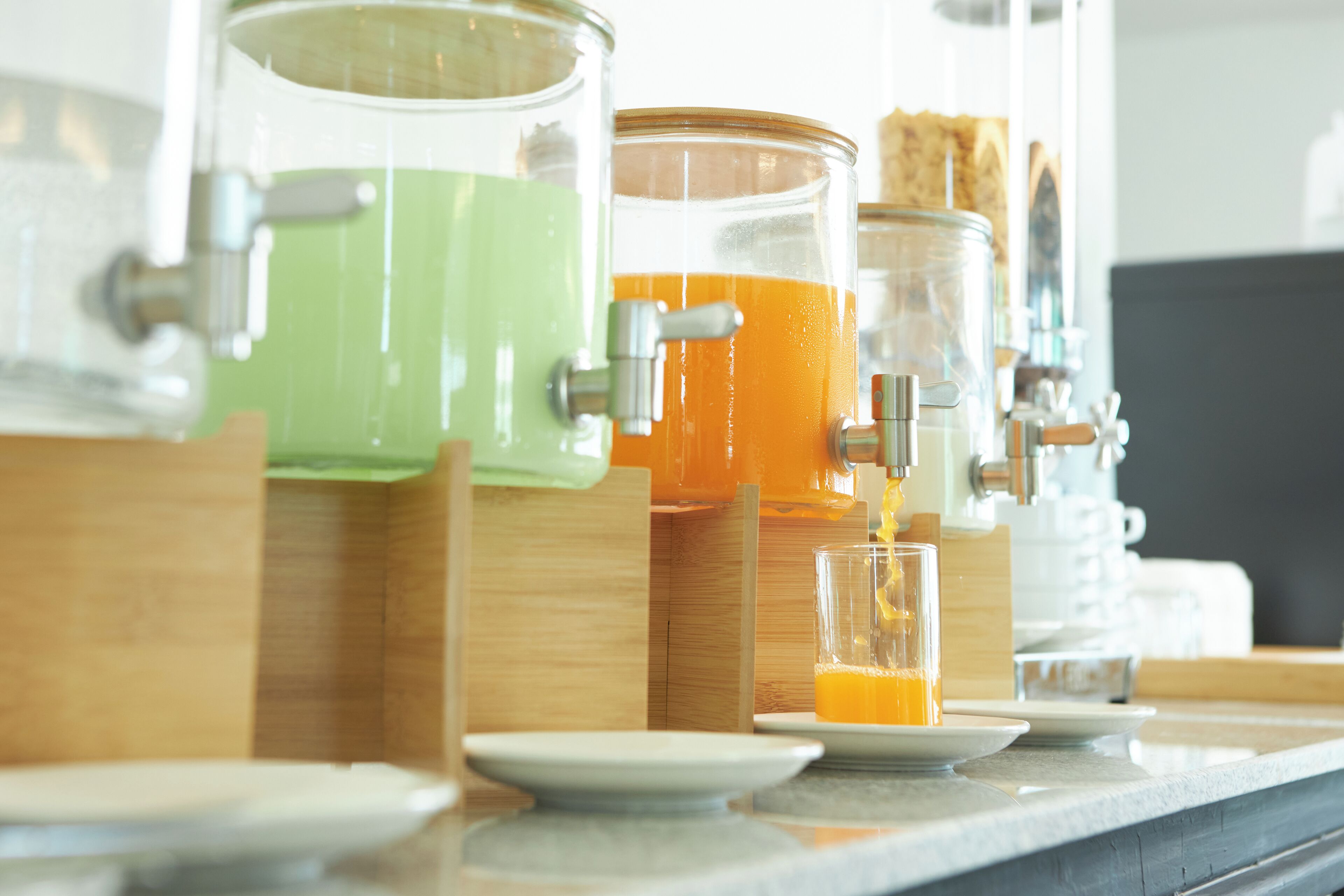 A beverage station with dispensers and glasses.