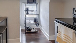 Une cuisine équipée d’un four encastré, d’un four à micro-ondes et d’une étagère pour ranger les ustensiles de cuisine.