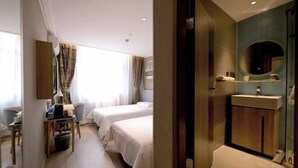 A hotel room with two beds, a desk with a chair, a small table, a mirror, and a bathroom with a sink and mirror. - Homeinn · neo (Beijing Ping'anli Subway Station) (Beijing)