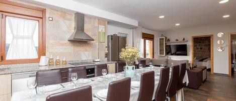 A modern kitchen with a dining area, granite countertops, and a large island.