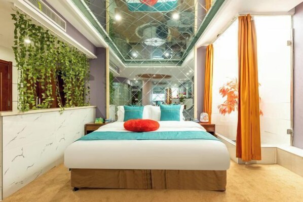 A modern bedroom with a large bed, a glass ceiling, and a view of the interior space.