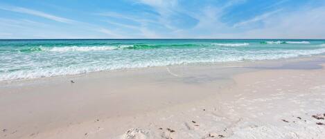 A beach with clear skies and calm waves.