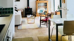 Una sala de estar acogedora con chimenea, comedor y cocina.