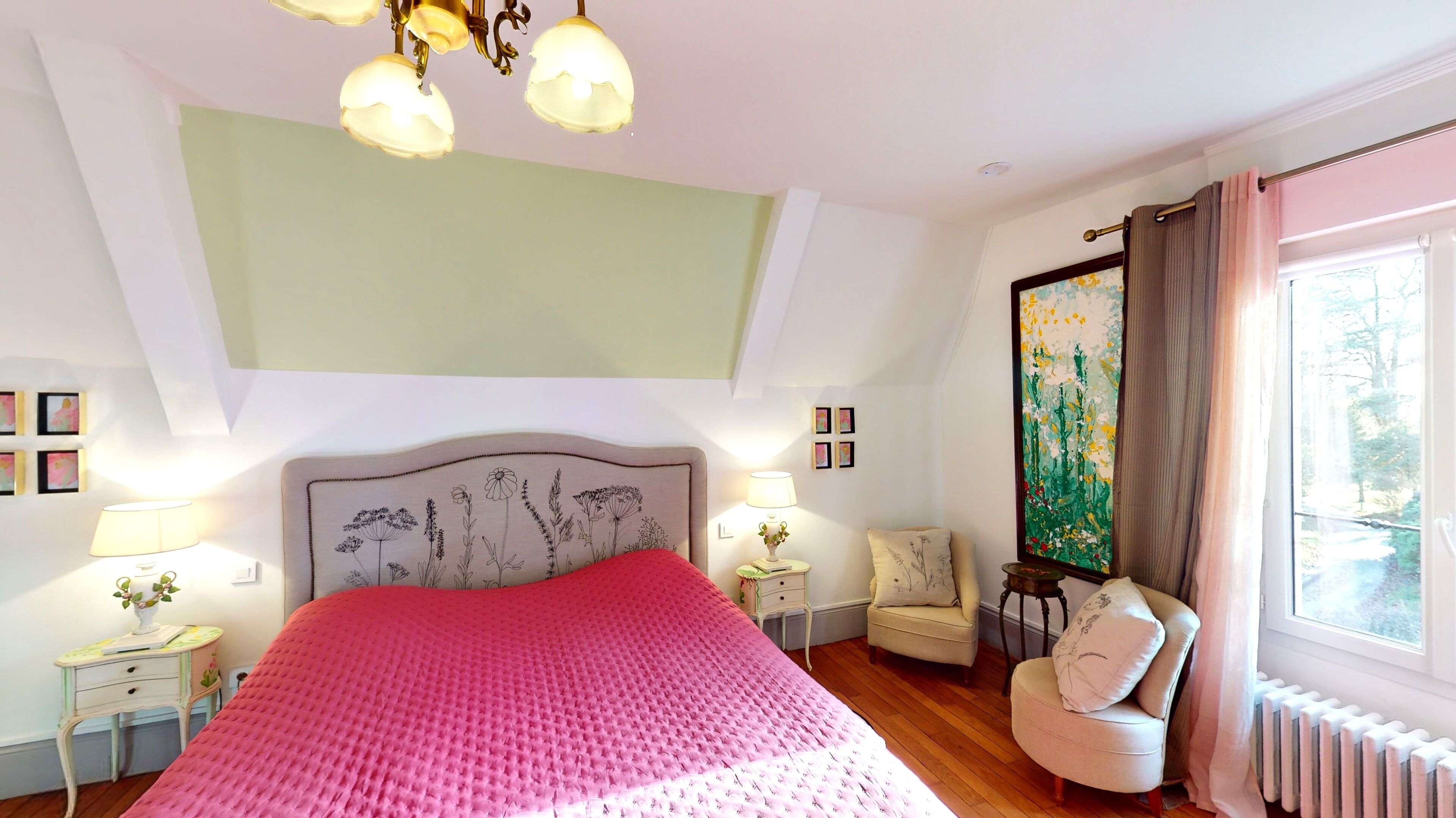 A bedroom with a large bed, a chair, a nightstand, a lamp, and a painting on the wall.