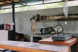 A kitchen area with a gas stove, a coffee maker, and various kitchen utensils on shelves. - Lullabi Lumbung Villa (West Lombok Regency)