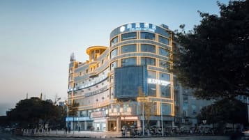 A multi-story hotel with a curved facade, multiple balconies, and signage indicating amenities like a restaurant and a spa.