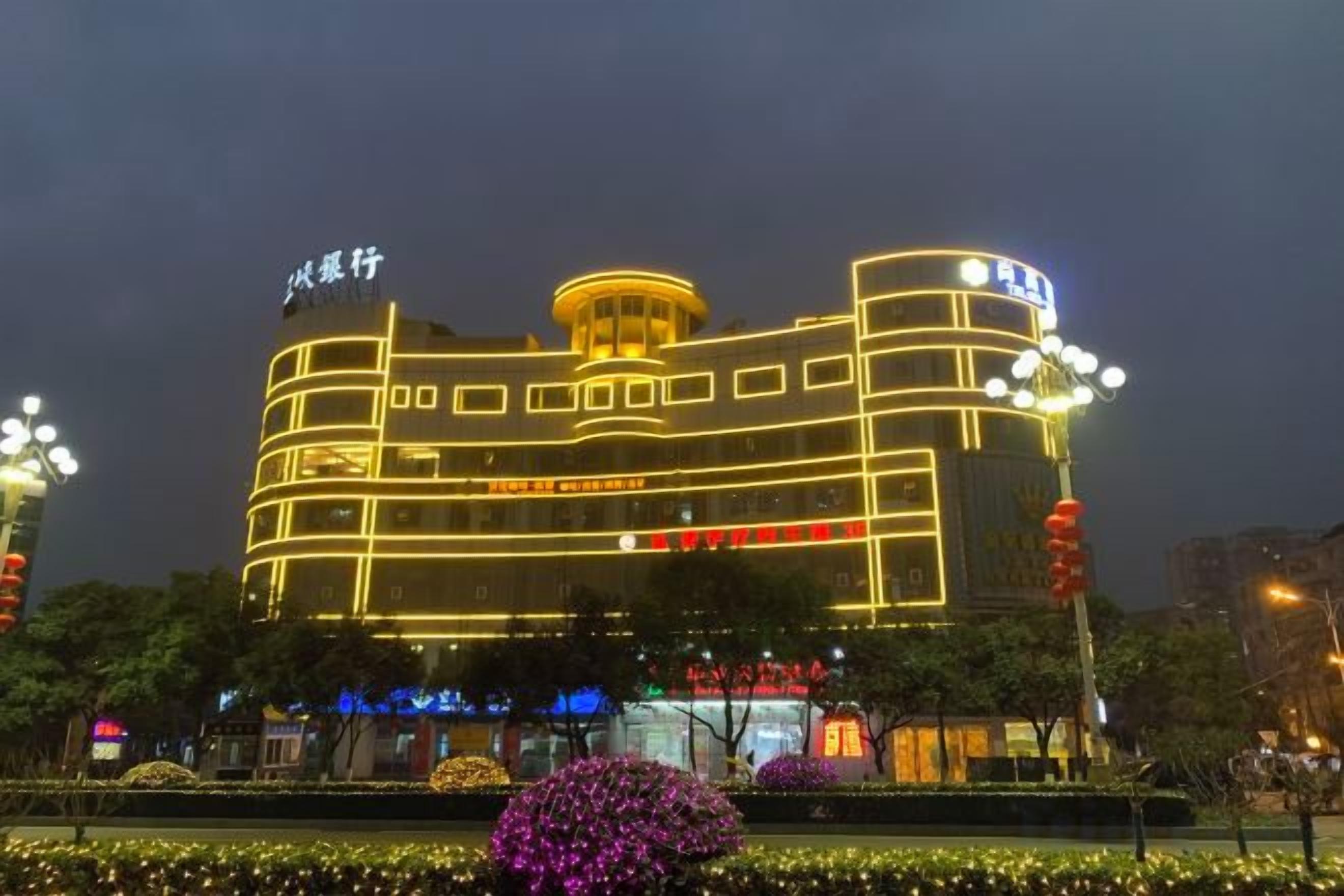 Un hôtel à plusieurs étages, doté d’une façade incurvée remarquable, illuminée par des lumières jaunes.