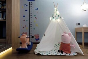 A child's play area with a tent, a height chart, and a Peppa Pig plush toy. - Shanggao Hotel (Chongqing)