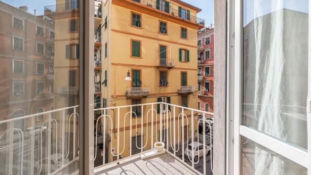 Un balcon avec une balustrade blanche, une chaise blanche et une table blanche.