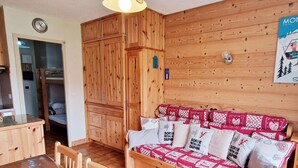 A cozy wooden room with a bunk bed, a small kitchenette, and a poster on the wall. - 100m from ski slopes, Ground floor, view valley, balcony, tv, 46m², Montalbert (La Plagne)