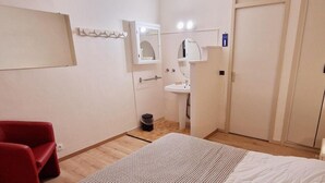 A small, neatly arranged bedroom with a single bed, a red chair, a white bedside table, a small sink, and a wardrobe. - 100m from ski slopes, Ground floor, view valley, balcony, tv, 46m², Montalbert (La Plagne)