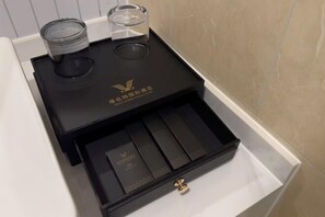 Una caja negra con un emblema dorado y un cajón con varios compartimentos.