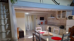 A dining area with a table, chairs, and a kitchen in the background. - Bienvenue Dans les Alpes de Hautes Provence . A Proximité des Gorges du Verdon (Beynes)