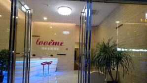 A reception area with a reception desk, a plant, and a sign that reads 'lovême.' - Love Me Couples' Theme Hotel (Guangzhou)
