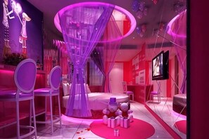 A room with a bed, a TV, and a large circular window. - Love Me Couples' Theme Hotel (Guangzhou)