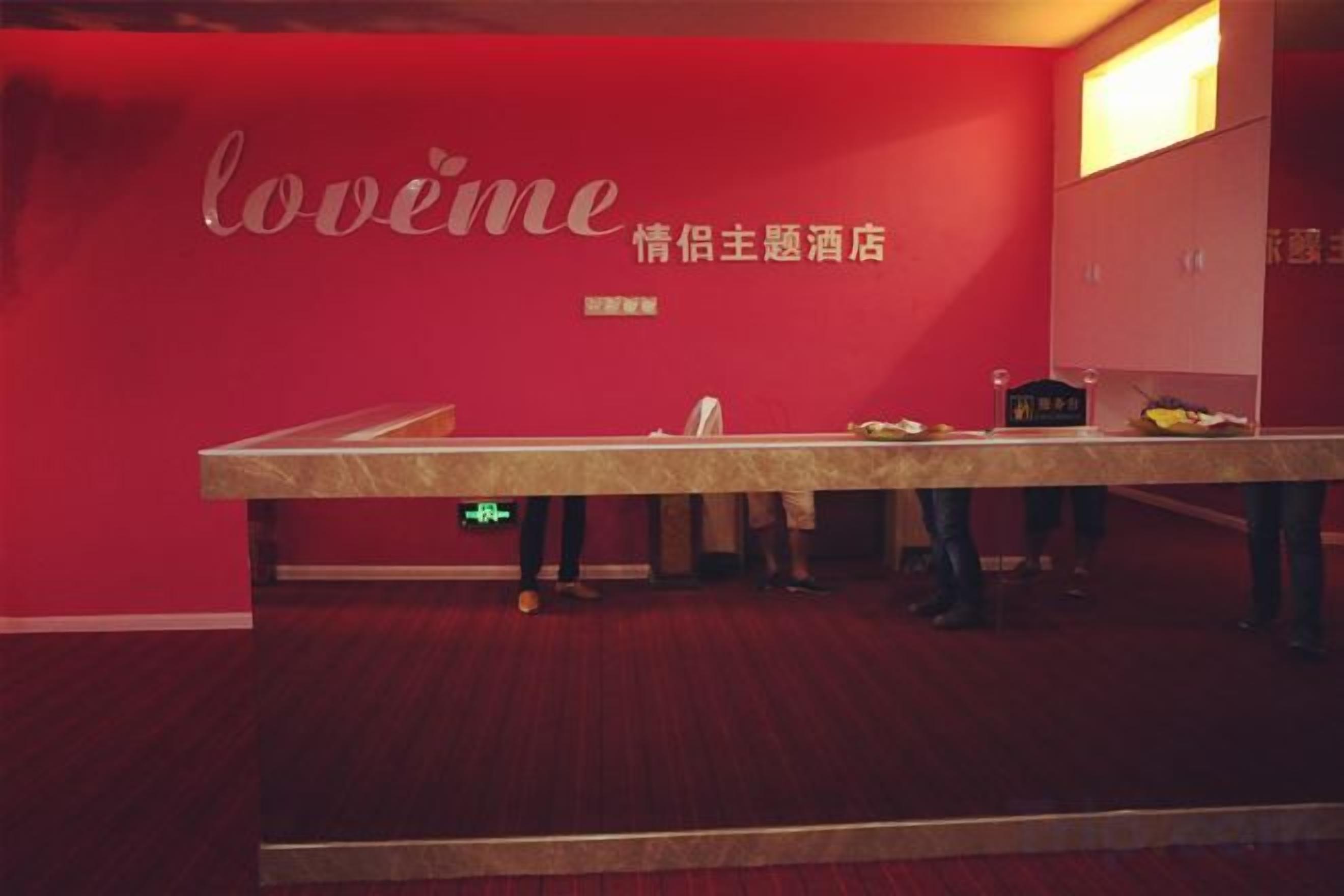 Een receptiezone met een rode muur en een receptiebalie.
