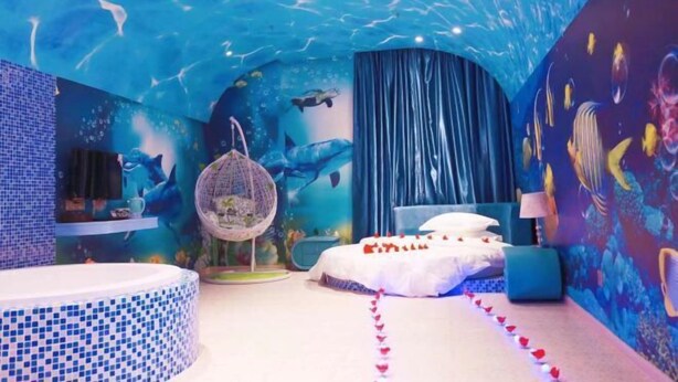 Una habitación con temática submarina, que incluye una cama, un sillón colgante y un globo terráqueo.