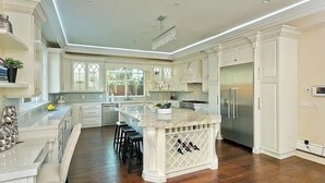 A spacious kitchen with white cabinetry, a central island with bar stools, a wine rack, and a large refrigerator. - Stunning Sherman Oaks Home minutes from all LA has to offer. Pool Oasis! (Los Angeles)