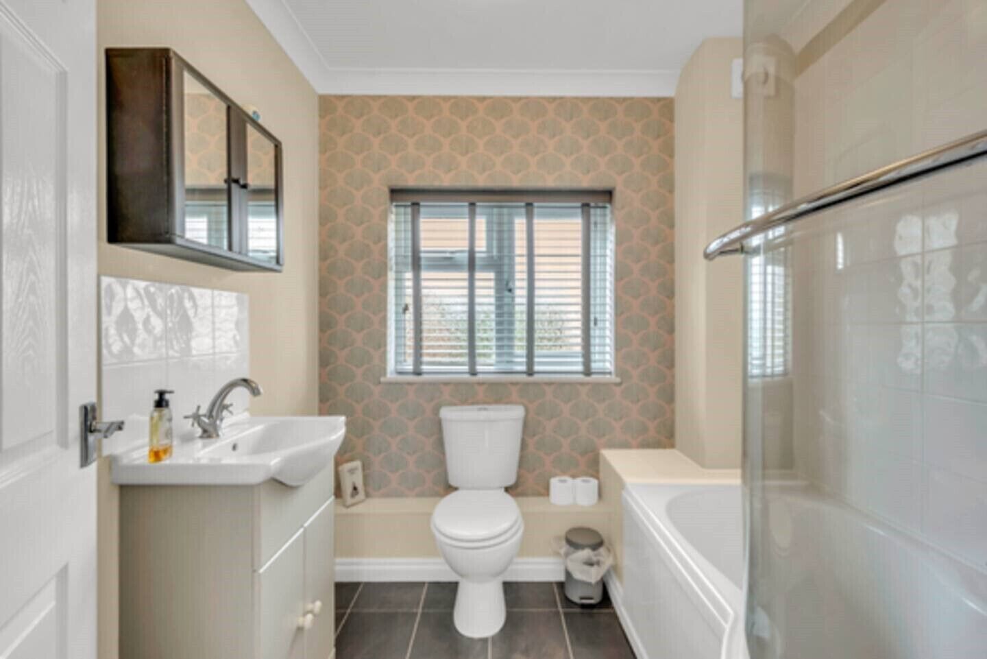 Une salle de bain avec des toilettes, un lavabo et une baignoire.