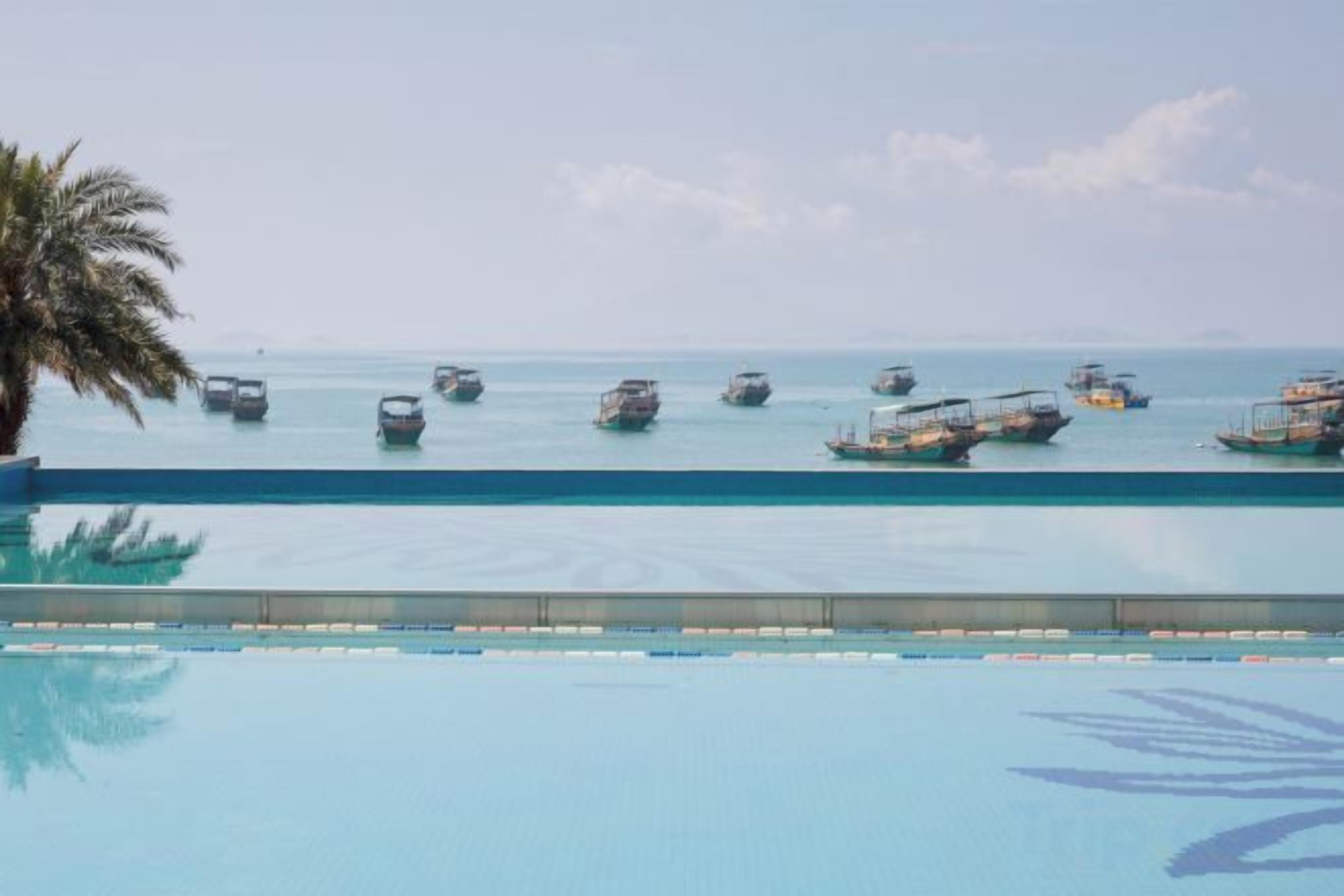 Una piscina con vistas a barcos en el agua.