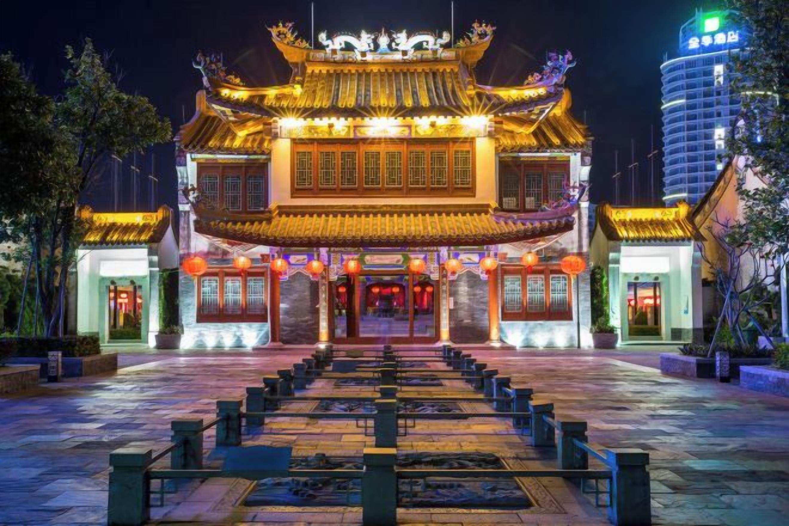 A traditional building with a symmetrical facade, large windows, and a central entrance.