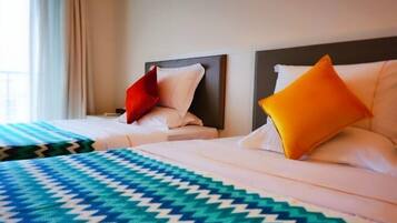 Duas camas de hotel com cabeceiras, um edredom estampado e almofadas.