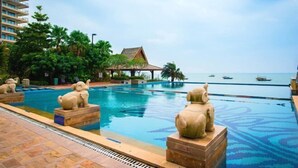 Une piscine ornée de statues d’éléphants, un bâtiment et une vue sur la mer.