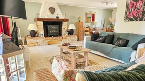 A cozy living room with a fireplace, comfortable seating, and a television. - Villa de Charme Avec Piscine - Idéale Pour des Vacances en Famille ou Entre Amis (Julienne)
