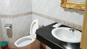 A bathroom with a toilet, sink, and mirror. - OYO 75466 13 Coins Bang Yai Hotel (Bang Yai)