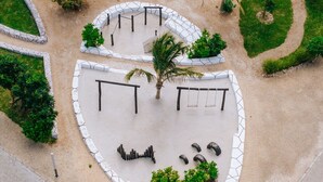 Eine Vogelperspektive eines angelegten Bereichs mit einer zentralen, runden Sitzgruppe, umgeben von geometrischen Mustern und viel Grün.